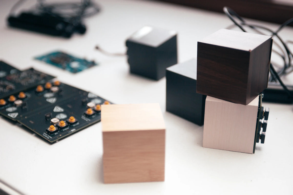 Wooden Skiparoo alarm cubes in different finishes beside circuit boards